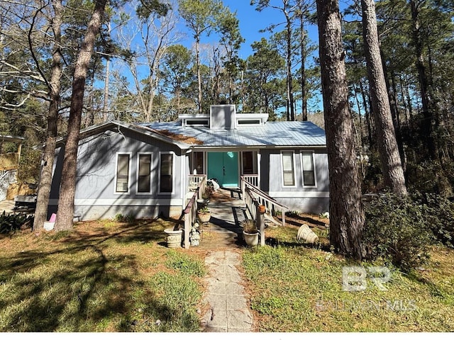 view of front of home featuring metal roof and a front yard