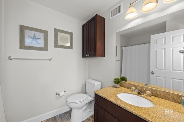 26115 Perdido Beach Blvd Unit 4-A, Orange Beach, AL 36561 - full bathroom featuring toilet, wood finished floors, vanity, baseboards, and a shower with shower curtain