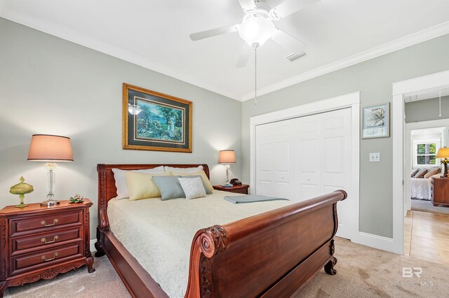 8954 Bay Point Dr, Elberta, AL 36530 - bedroom featuring a closet, ornamental molding, visible vents, light carpet, and baseboards