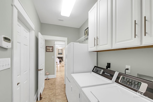 8954 Bay Point Dr, Elberta, AL 36530 - washroom featuring visible vents, light tile patterned flooring, baseboards, washer and clothes dryer, and cabinet space
