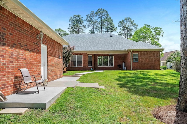 8954 Bay Point Dr, Elberta, AL 36530 - back of property with brick siding, a shingled roof, and a yard