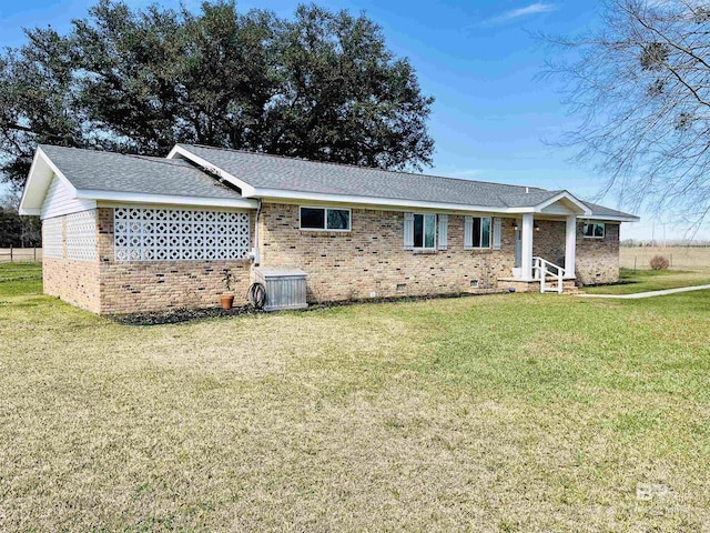 view of front of house featuring a front yard, crawl space, brick siding, and roof with shingles