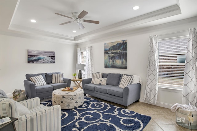 living room featuring a healthy amount of sunlight, a raised ceiling, and light tile patterned floors