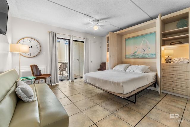 bedroom with a textured ceiling, light tile patterned floors, and ceiling fan