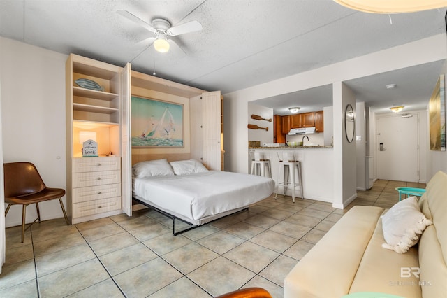 tiled bedroom featuring ceiling fan and a textured ceiling