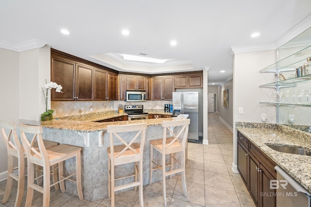 23450 Perdido Beach Blvd Unit 2209, Orange Beach, AL 36561 - kitchen with stainless steel appliances, ornamental molding, backsplash, light stone countertops, and a kitchen breakfast bar