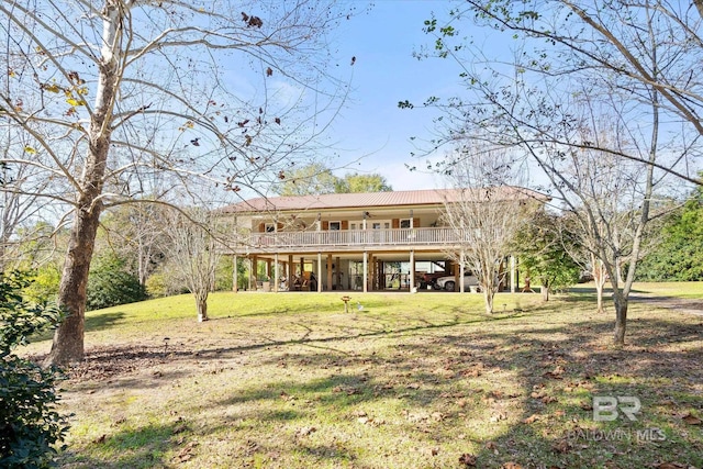 rear view of property featuring a lawn