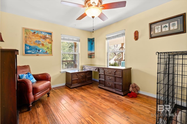 sitting room with ceiling fan and light wood-type flooring