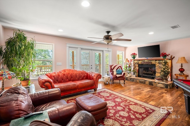 living room featuring ceiling fan, a healthy amount of sunlight, wood-type flooring, and french doors