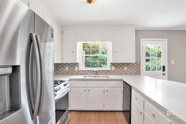 kitchen featuring sink, appliances with stainless steel finishes, backsplash, and light hardwood / wood-style flooring