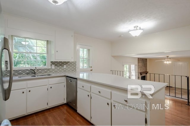 kitchen featuring wood-type flooring, ceiling fan, kitchen peninsula, and backsplash