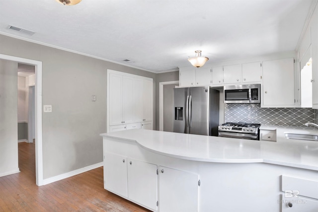 kitchen featuring backsplash, light hardwood / wood-style flooring, stainless steel appliances, white cabinetry, and sink