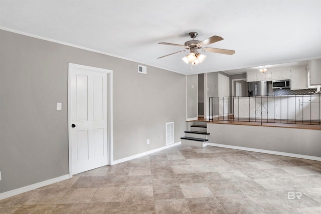 tiled spare room featuring ceiling fan and crown molding