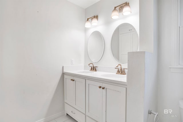 bathroom with toilet, tile floors, and dual vanity