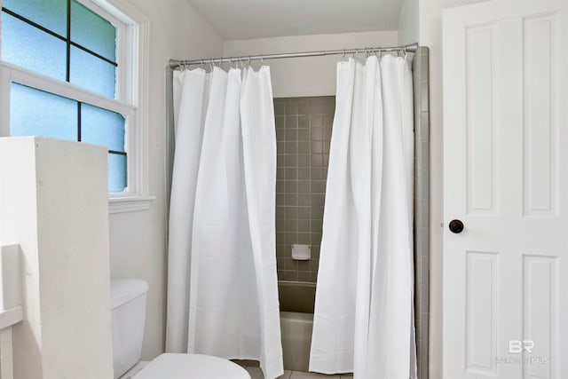 bathroom featuring shower / bath combination with curtain and toilet