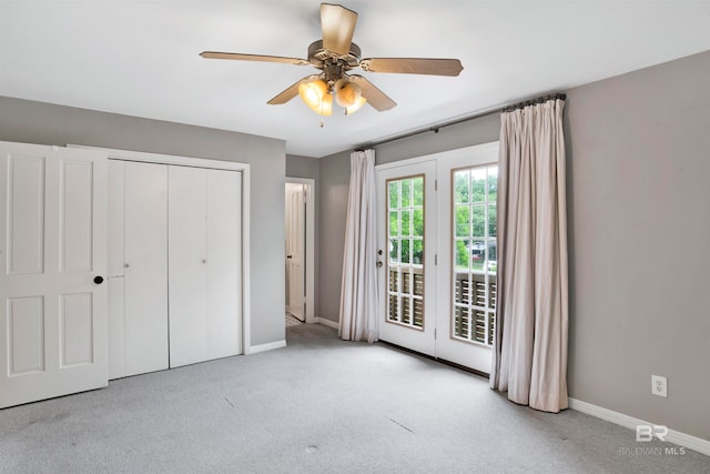 unfurnished bedroom with light colored carpet, a closet, and ceiling fan