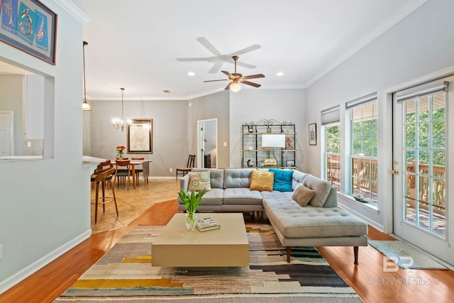 living room featuring crown molding, light wood-type flooring, and ceiling fan with notable chandelier