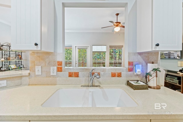 kitchen featuring ornamental molding, white cabinetry, tasteful backsplash, and sink