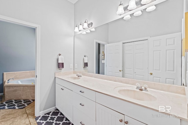 bathroom featuring vanity, a relaxing tiled tub, and tile patterned flooring