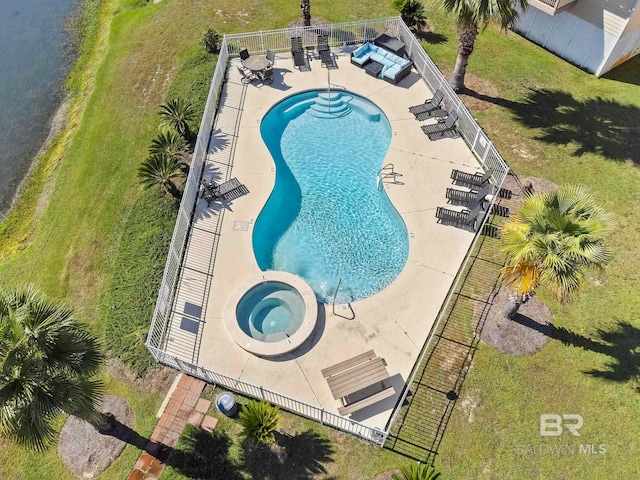 view of swimming pool with a hot tub, a patio, and a lawn