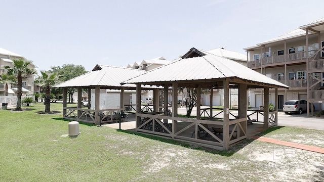 view of dock featuring a gazebo, a patio, a lawn, and a balcony