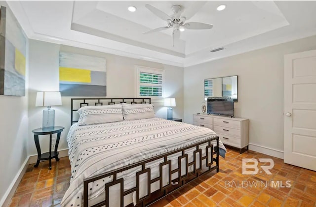 bedroom with a tray ceiling and ceiling fan