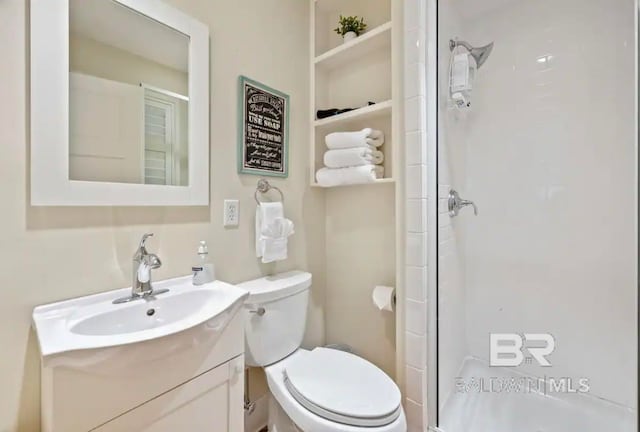 bathroom with an enclosed shower, vanity, and toilet