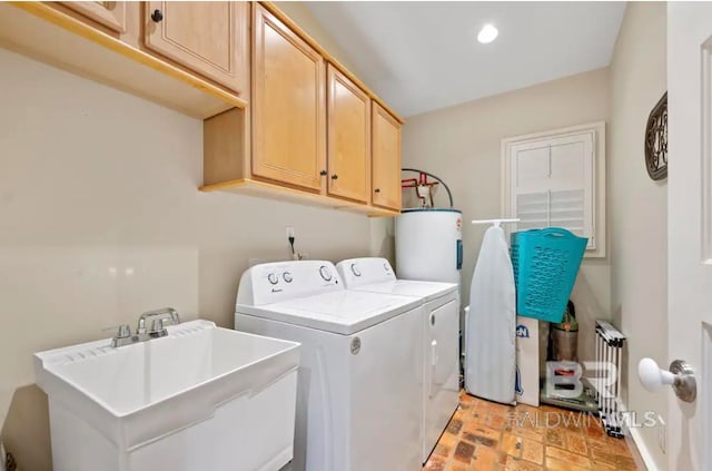 clothes washing area with cabinets, electric water heater, radiator, sink, and washer and dryer