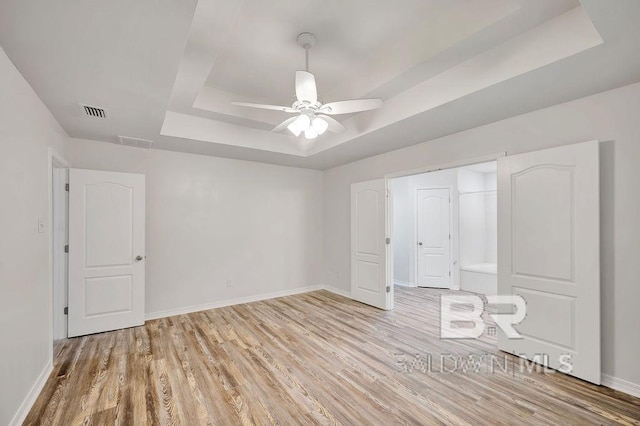 31246 Shambo Rd, Spanish Fort, AL 36527 - unfurnished bedroom with a raised ceiling, light wood-type flooring, and ceiling fan