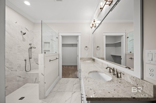 bathroom featuring a sink, marble finish floor, a tile shower, and ornamental molding