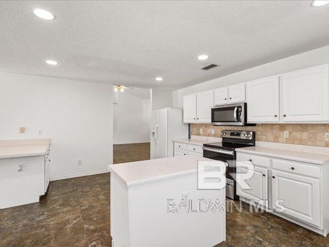 11554 Braga Dr, Daphne, AL 36526 - kitchen with stainless steel appliances, tasteful backsplash, white cabinetry, a textured ceiling, and a center island
