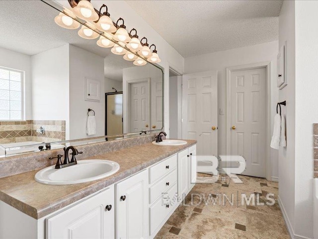 11554 Braga Dr, Daphne, AL 36526 - bathroom featuring a shower stall, a textured ceiling, a garden tub, and double vanity
