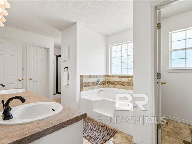 11554 Braga Dr, Daphne, AL 36526 - full bath featuring a bath, a stall shower, a textured ceiling, and double vanity