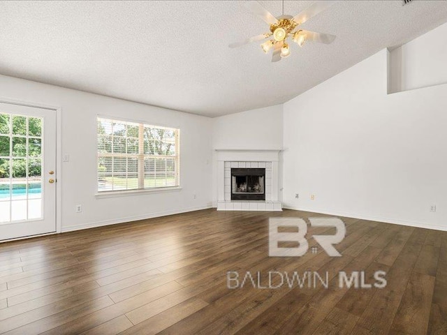 11554 Braga Dr, Daphne, AL 36526 - unfurnished living room with a textured ceiling, wood finished floors, ceiling fan, a tile fireplace, and lofted ceiling