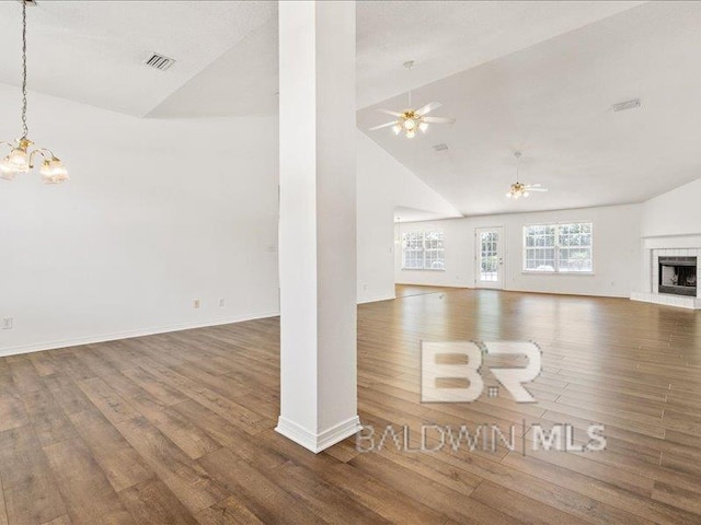 11554 Braga Dr, Daphne, AL 36526 - unfurnished living room featuring wood finished floors, a chandelier, a fireplace, baseboards, and high vaulted ceiling