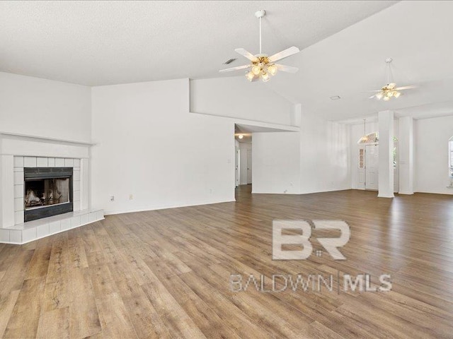 11554 Braga Dr, Daphne, AL 36526 - unfurnished living room with ceiling fan, wood finished floors, a fireplace, and high vaulted ceiling
