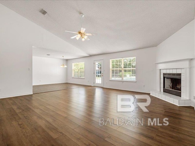11554 Braga Dr, Daphne, AL 36526 - unfurnished living room featuring wood finished floors, a fireplace, ceiling fan, a textured ceiling, and a chandelier