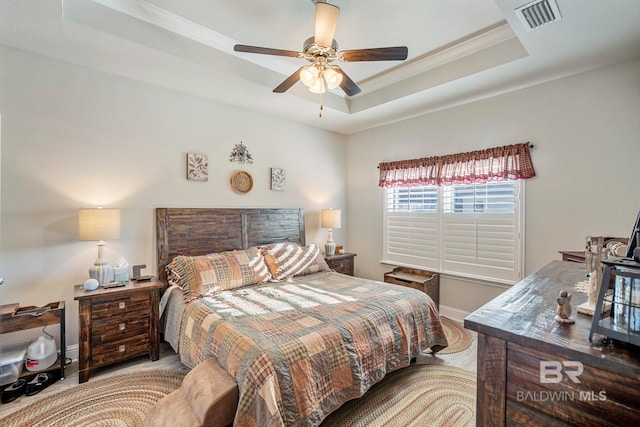 bedroom featuring light hardwood / wood-style flooring, ornamental molding, ceiling fan, and a raised ceiling