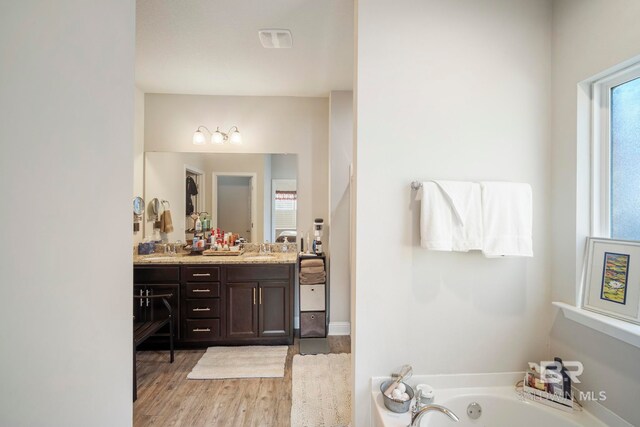 bathroom featuring vanity, a tub, and hardwood / wood-style flooring