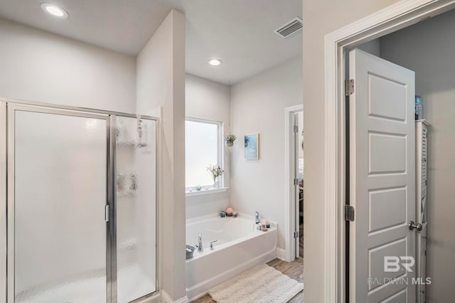 bathroom featuring hardwood / wood-style flooring and independent shower and bath