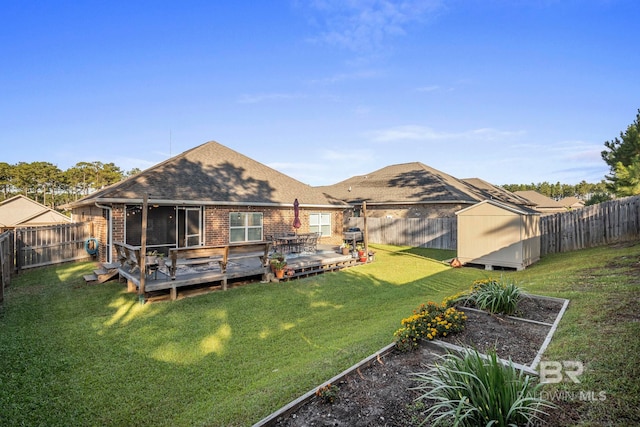 rear view of property featuring a wooden deck, a storage unit, and a lawn