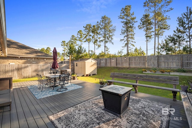 wooden deck with a storage shed and a lawn