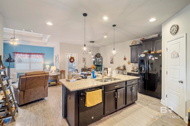 kitchen featuring dishwasher, a center island with sink, sink, decorative light fixtures, and black fridge with ice dispenser