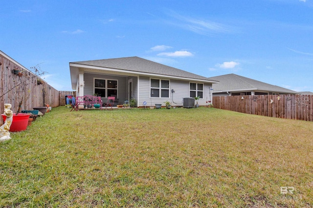 rear view of house with a yard and central air condition unit