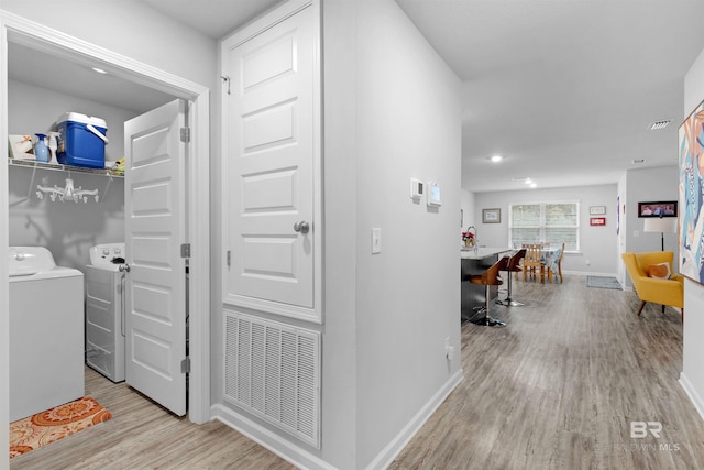 corridor featuring washer and dryer and light hardwood / wood-style floors