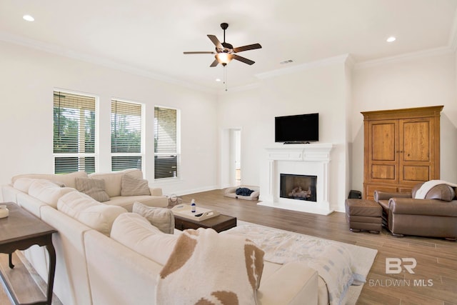 22258 Hibiscus Cir, Foley, AL 36535 - living area featuring wood finished floors, visible vents, a fireplace with raised hearth, ornamental molding, and ceiling fan