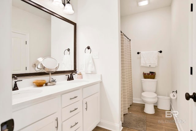 22258 Hibiscus Cir, Foley, AL 36535 - bathroom with double vanity, toilet, wood finished floors, and a sink