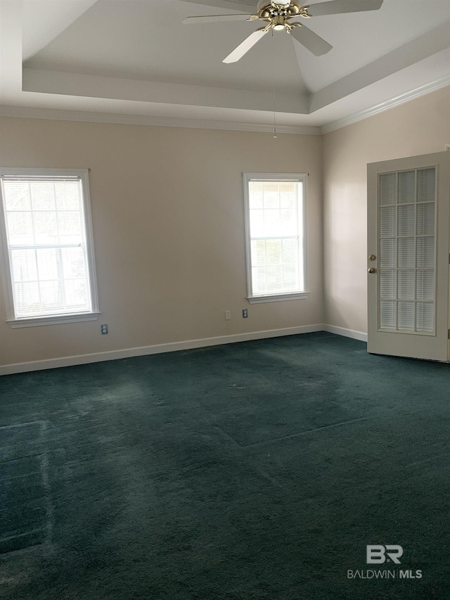 carpeted empty room with crown molding, a tray ceiling, and ceiling fan