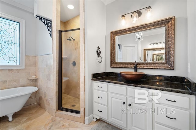 bathroom featuring vanity, independent shower and bath, tile walls, and tile patterned flooring