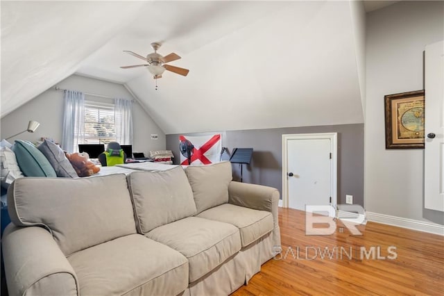 living room with hardwood / wood-style flooring, ceiling fan, and vaulted ceiling